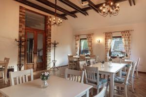 a dining room with tables and chairs and windows at Vén Diófa in Sub Cetate