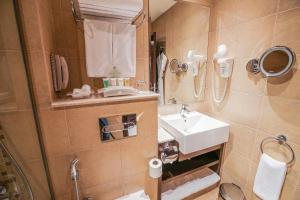 a bathroom with a sink and a mirror at Copthorne Downtown by Millennium in Abu Dhabi