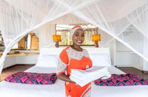 a woman standing in a room with two beds at Jua Retreat in Michamvi