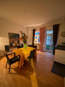a living room with a yellow table and chairs at Apartment Elli in Augsburg