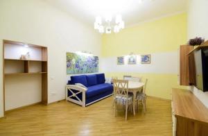 sala de estar con sofá azul y mesa en Сучасні Апартаменти на Площі Ринок з балконом en Leópolis