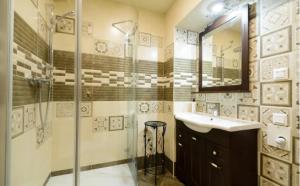 een badkamer met een douche, een wastafel en een spiegel bij Сучасні Апартаменти на Площі Ринок з балконом in Lviv
