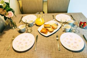 a table with plates of food and utensils on it at Hauzify I Apartaments Grup Claustre in Torredembarra