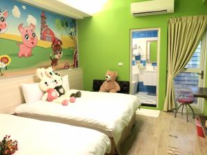 una camera con due letti con sopra animali di peluche di Jiahui Elevator Homestay a Città di Taitung