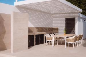 un patio con mesa y sillas en Villa No 1 - Cap St Georges Resort, en Peyia