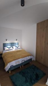 sypialnia z dużym łóżkiem z niebieskim zagłówkiem w obiekcie APARTAMENT BLUE , Marynarska 8 , Sarbinowo w Sarbinowie