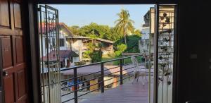 um quarto com uma varanda com vista para um quintal em Little Guest House Hotel em Chiang Mai