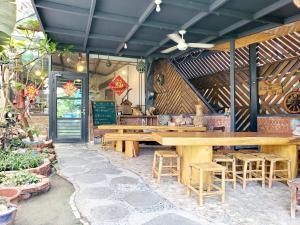 un restaurante con mesas y taburetes de madera en Stone Home Bed and Breakfast, en Taitung