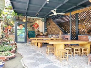 a restaurant with wooden tables and stools at Stone Home Bed and Breakfast in Taitung City