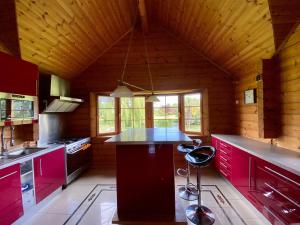 una cocina con armarios rojos y una isla en una cabaña en Norman XXL Cottage 3 stars 15' drive to the beach and perfect to seminaries, en Sauqueville
