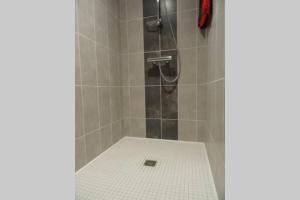 a bathroom with a shower with a white tile floor at studio entre Mt-St-Michel et St- Malo in Dol-de-Bretagne +18 photos