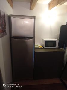 um frigorífico numa cozinha ao lado de um micro-ondas em Studio à la campagne aux portes de Nantes em Saint-Mars-du-Désert