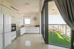 耶路撒冷Gorgeous Design 3 BDR Appart - J Tower - Amazing View!的厨房配有白色橱柜和大窗户