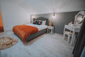 a bedroom with a bed and a desk and a mirror at Casa DAnto in Şelimbăr