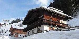 een gebouw in de sneeuw met sneeuw erop bij Texas Longhorn Ranch Neumannhof in Cadipietra