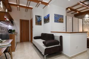 a living room with a couch and a kitchen at Studio Apartment San Marino in Dubrovnik in Dubrovnik