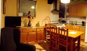 uma cozinha com uma mesa de madeira, uma mesa e cadeiras em Casa Melania em Cepeda