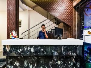 a man talking on a cell phone in a room at THE ELITE INN in Visakhapatnam