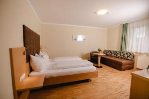 uma sala de estar com uma cama e um sofá em Gasthof Rothwangl Hannes em Krieglach