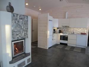 a kitchen with a fireplace in the middle of a room at Ankkuri Raijan Aitta in Mikkeli