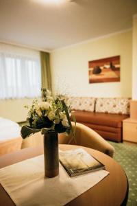 un jarrón de flores sobre una mesa en una habitación de hotel en Gasthof Rothwangl Hannes, en Krieglach