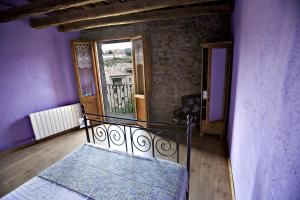 sypialnia z łóżkiem w pokoju z fioletowymi ścianami w obiekcie Cal Ferrer Nou w mieście Alpens