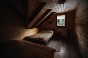 a room with two beds in a wooden cabin at Csángó Panoráma in Valea Rece