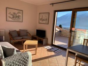 a living room with a couch and a tv and a balcony at Al Borgo in Gravedona