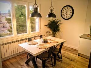 a dining room table with chairs and a clock on the wall at Apartamento Gaztainondoak(II)A 10min de Laguardia in Lanciego
