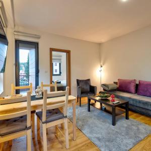 兹拉蒂博尔Zlatibor apartman Asteri的客厅里有一张桌子和一张沙发