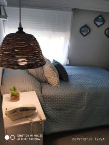 ein Schlafzimmer mit einem Bett mit einem Tisch und einer Lampe in der Unterkunft Apartamento Marina de roosvelt con piscina climatizada in Punta del Este