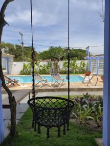 a swing in front of a swimming pool at Pousada Manaaki in Búzios