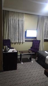 um quarto de hotel com uma cama, uma mesa e uma cadeira em koza millenyum hotel&spa em Ancara