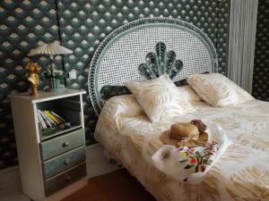 a bedroom with a bed with a large headboard and a table at Pause Campagne - Chambres d'Hôtes in Pouy-de-Touges