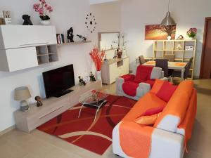 een woonkamer met een bank en een tv bij LA MAISON - CRISPIANO in Crispiano