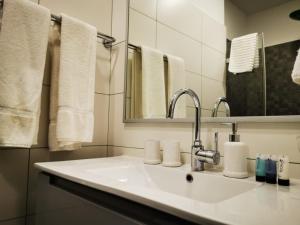 a bathroom with a sink and a mirror and towels at Central Boutique Hotel in Jerusalem