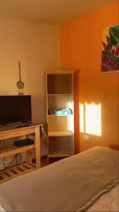 1 dormitorio con 1 cama y escritorio con TV en Avetaia Suit en Santa Rosa de Calamuchita