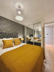 a bedroom with a large bed with a yellow blanket at Bijou Merchant City Apartment with Parking (Albion 1) in Glasgow