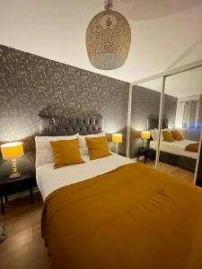 a bedroom with a large bed with yellow pillows at Bijou Merchant City Apartment with Parking (Albion 1) in Glasgow