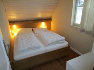 伯爾格倫德－雷特維施的住宿－Ferienwohnung Möwe mit eigener Sauna，卧室内的一张带白色枕头的大床