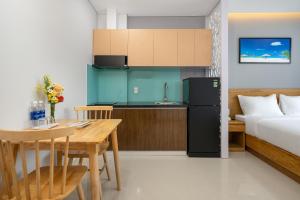 a kitchen and a bedroom with a bed and a table at ST Motel & Apartment in Danang