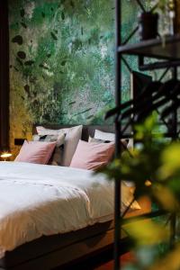 a bedroom with a bed with pink pillows at Daen’s Greenhouse in Utrecht