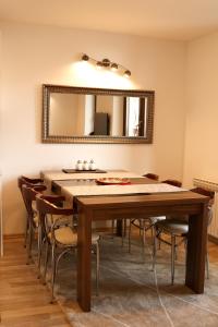 ein Esszimmer mit Tisch und Spiegel in der Unterkunft Apartmani Stelo Jahorina in Jahorina
