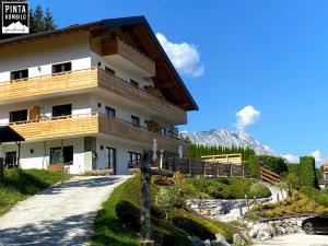 ein Gebäude mit einem Berg im Hintergrund in der Unterkunft Pinta Kombilo Apartments in Gröbming