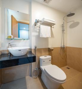 La salle de bains est pourvue d'un lavabo, de toilettes et d'un miroir. dans l'établissement ST Motel & Apartment, à Đà Nẵng