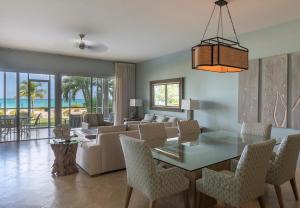 a living room with a couch and a table and chairs at The Venetian on Grace Bay in Grace Bay