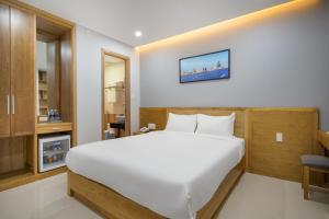 a bedroom with a large white bed in a room at ST Motel & Apartment in Danang +28 photos