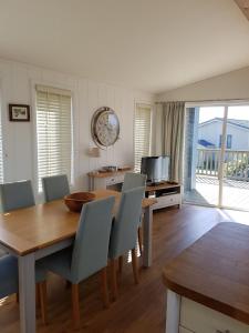 uma sala de jantar com uma mesa de madeira e cadeiras em Midships Lodge em Salcombe
