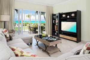 a living room with a television and a table at The Venetian on Grace Bay in Grace Bay