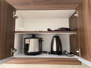 a kitchen cabinet with a coffee maker and a toaster at Twin Bed Unit- MIGAs Haven at Sunvida Tower in Cebu City